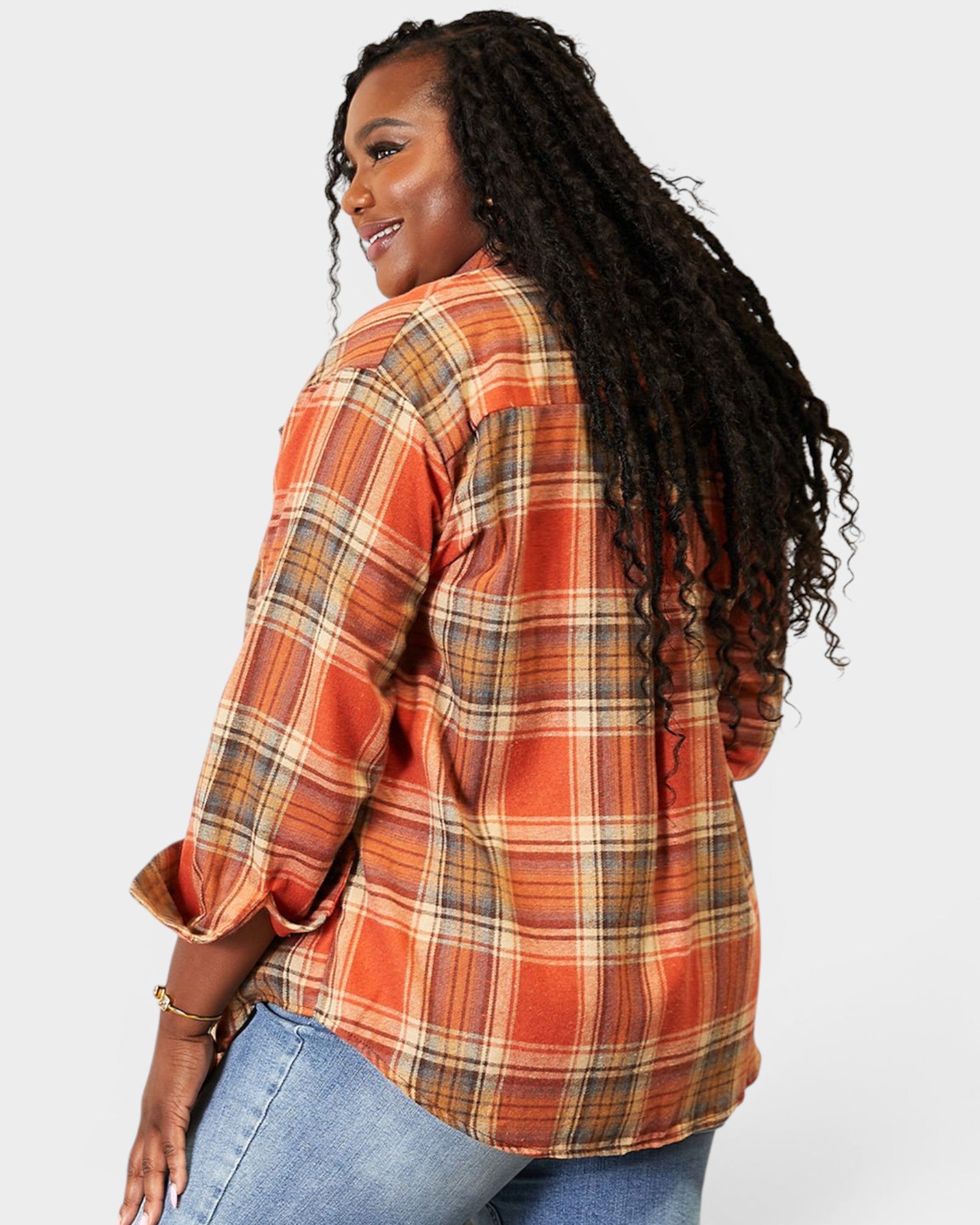 Person wearing an orange plaid shirt with a plain background