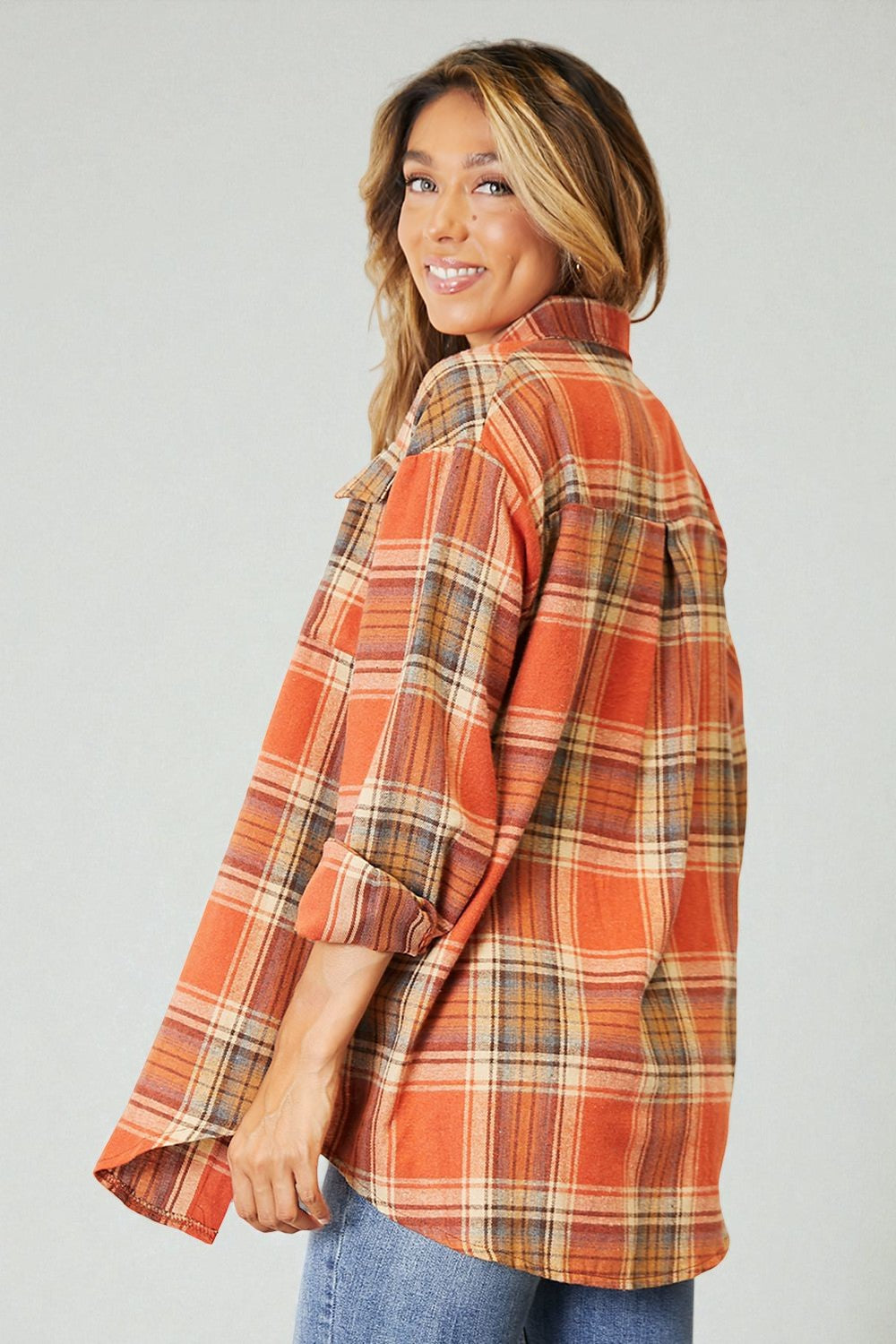 Woman wearing a plaid shirt with a neutral background