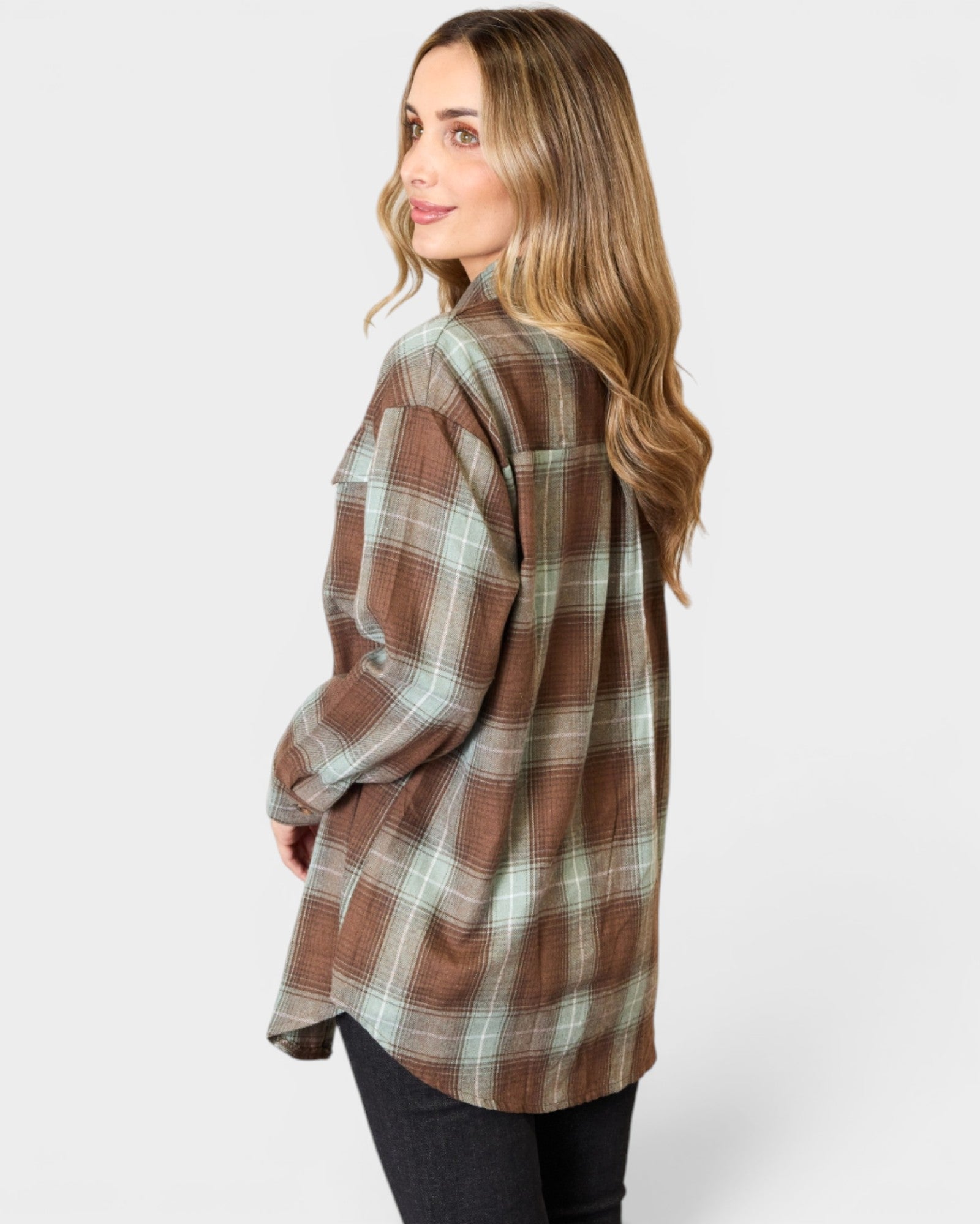 Woman wearing a brown and green plaid shirt on a white background