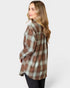 Woman wearing a brown and green plaid shirt on a white background