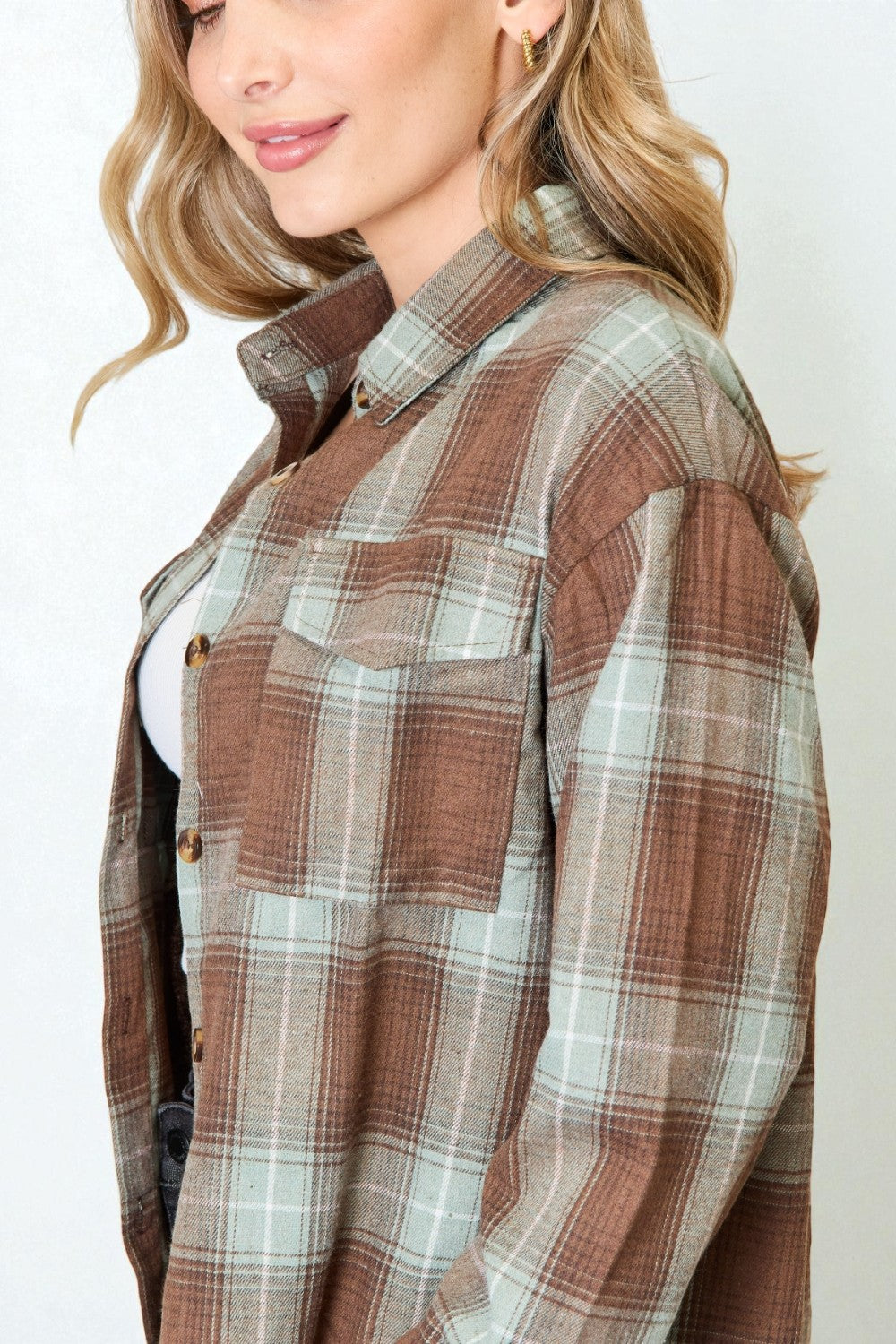 Woman wearing a plaid shirt with a neutral background