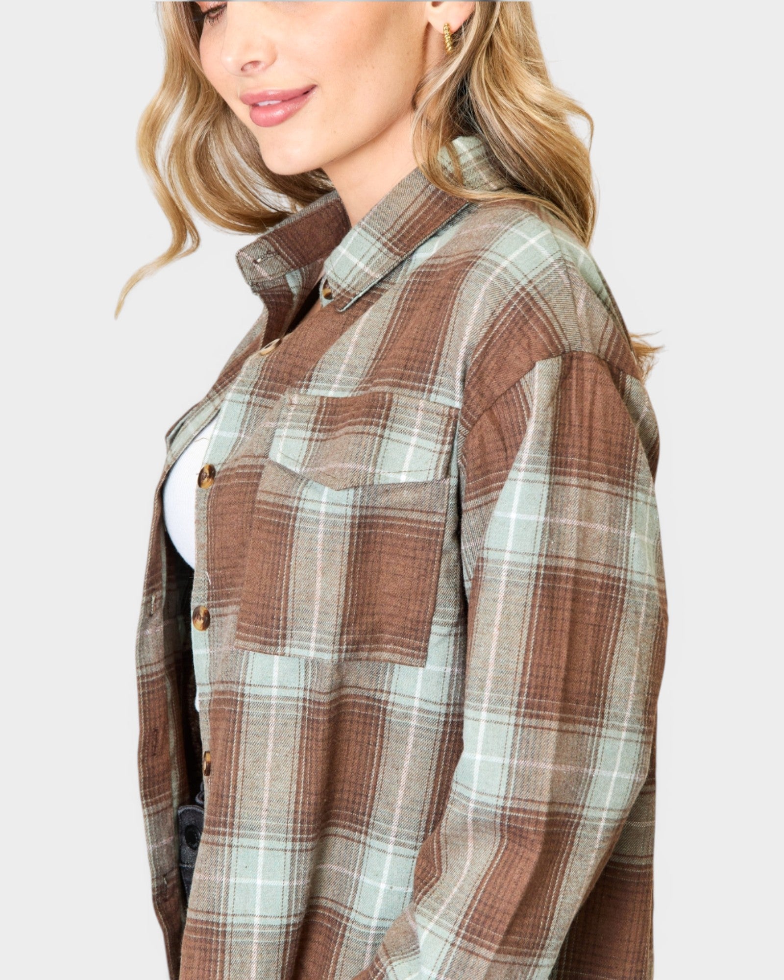 Woman wearing a plaid shirt with a neutral background