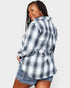 Woman wearing a plaid shirt and denim shorts on a white background