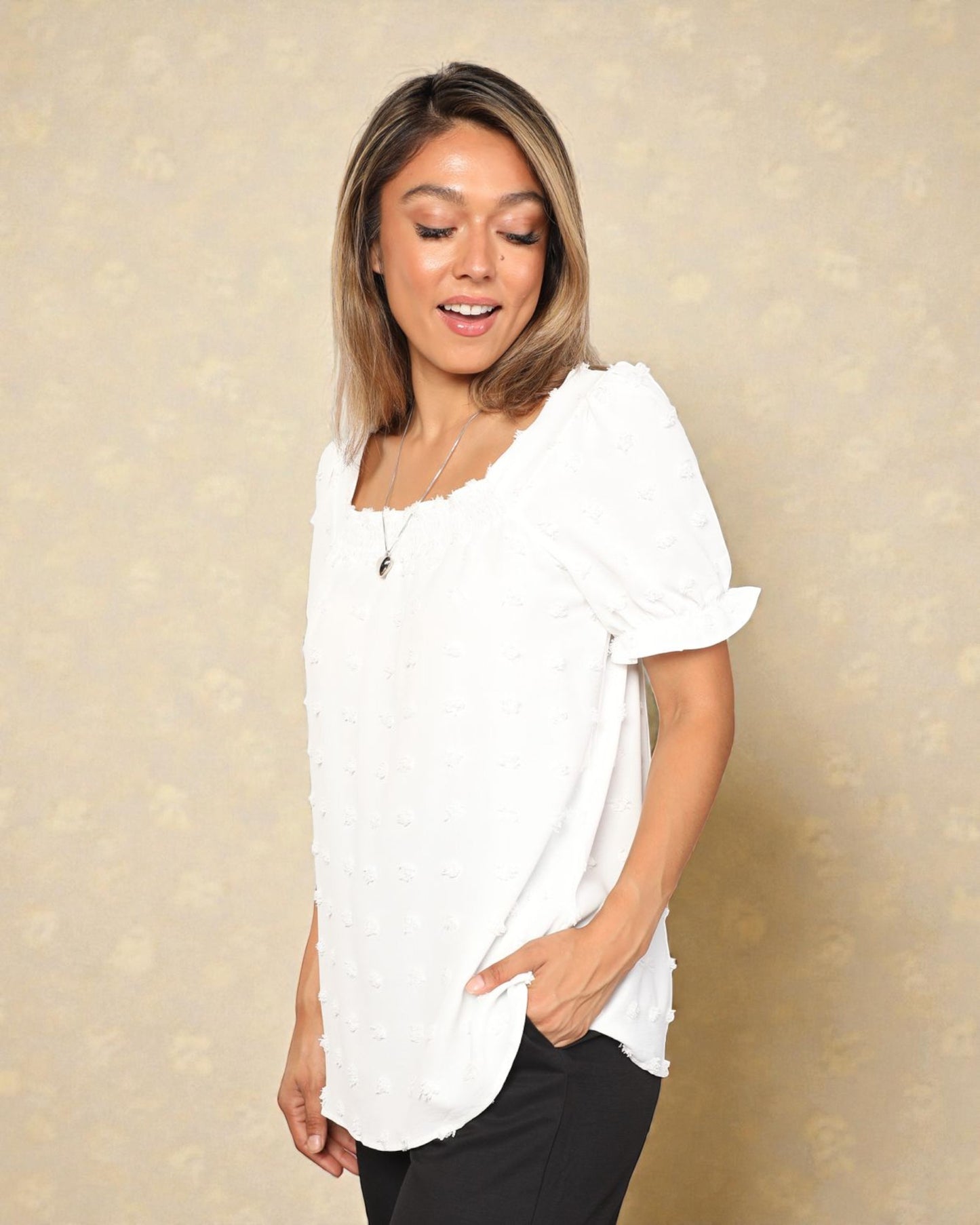 Woman wearing a white blouse against a beige background