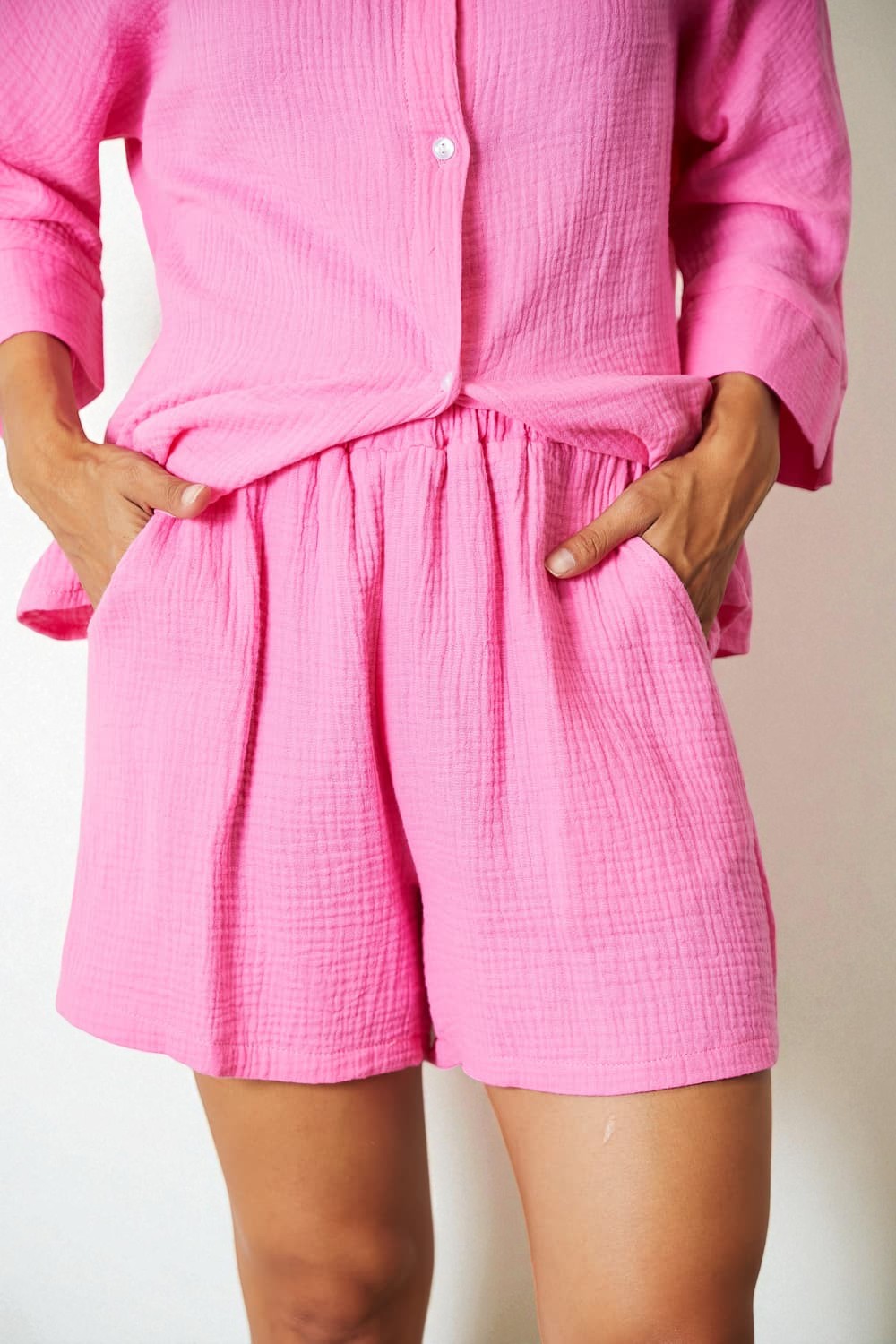 Person wearing a pink romper with a plain background