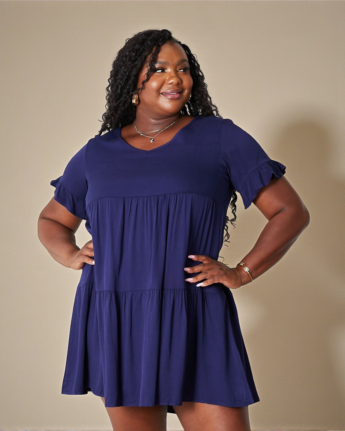 Woman wearing a blue dress against a beige background