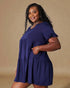 Woman wearing a blue dress against a beige background