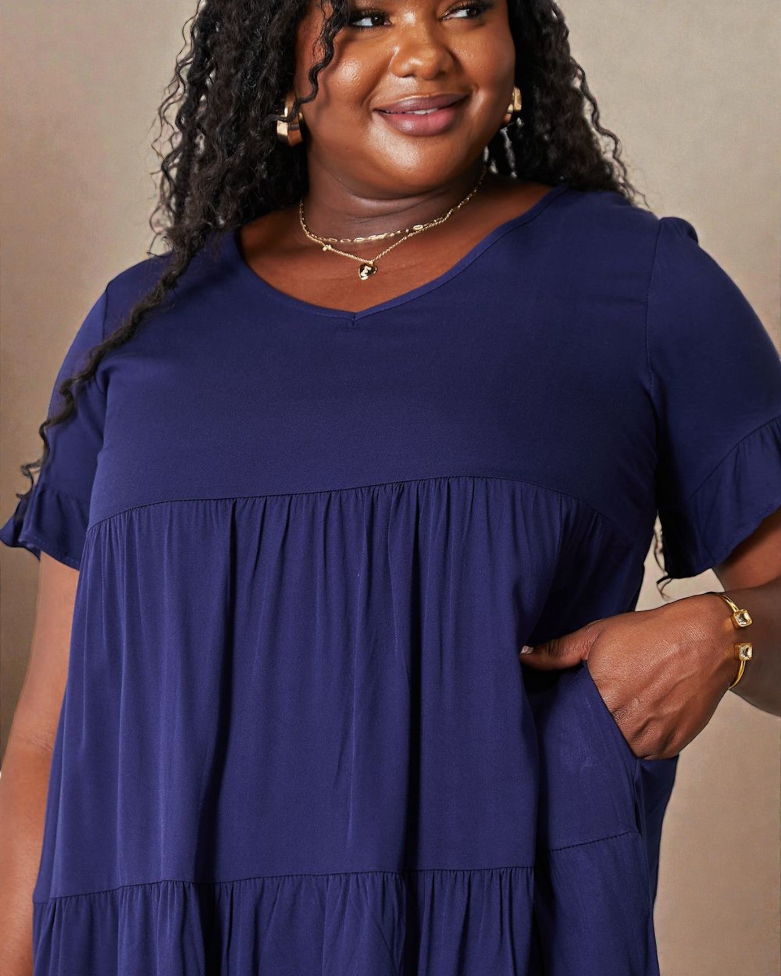 Woman wearing a blue dress against a beige background