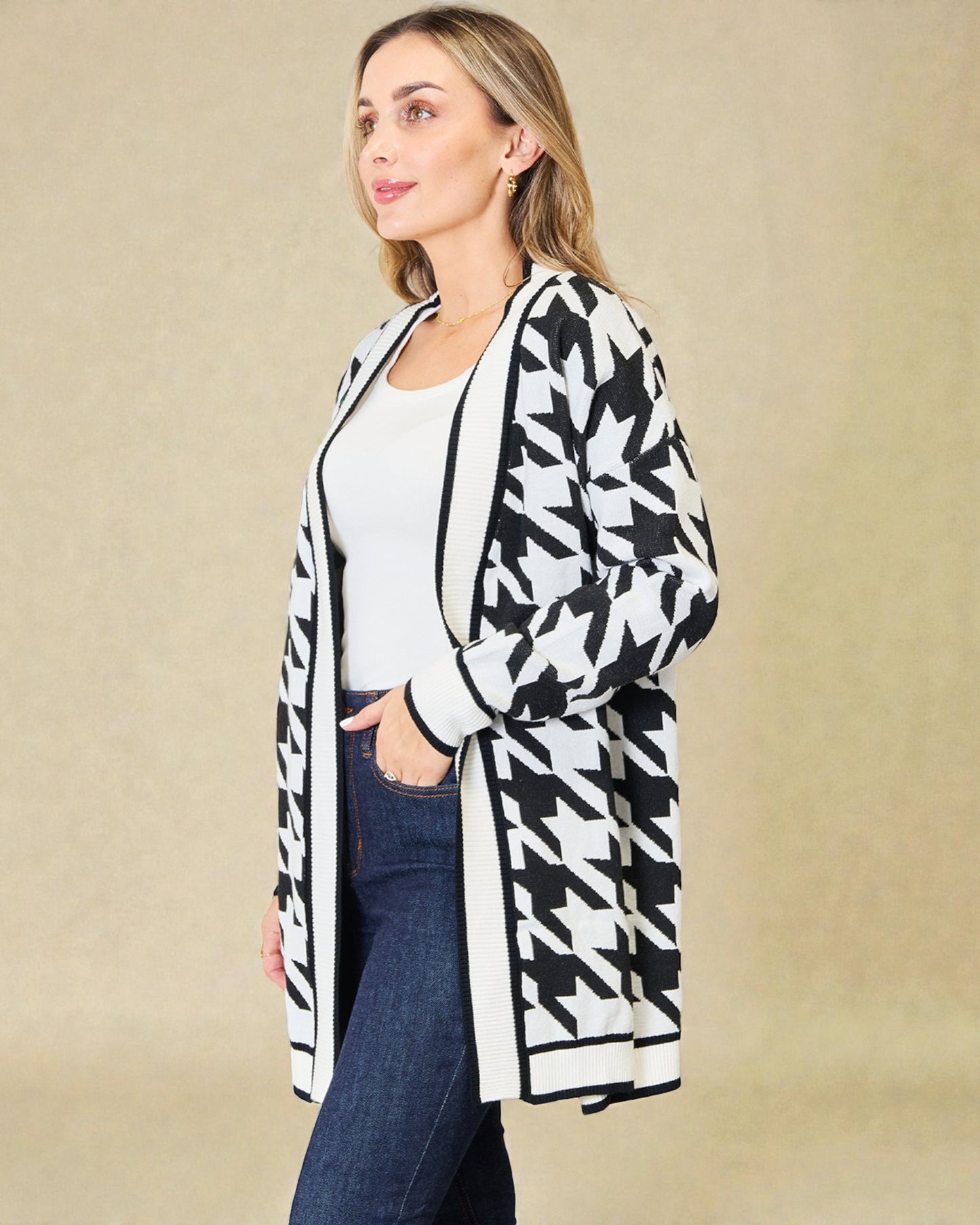 Woman wearing a black and white patterned cardigan on a beige background