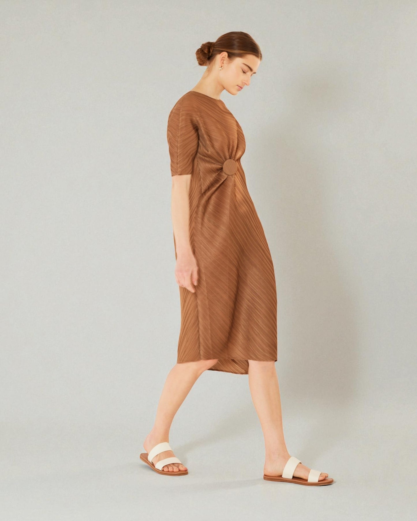 Woman wearing a brown dress on a plain background