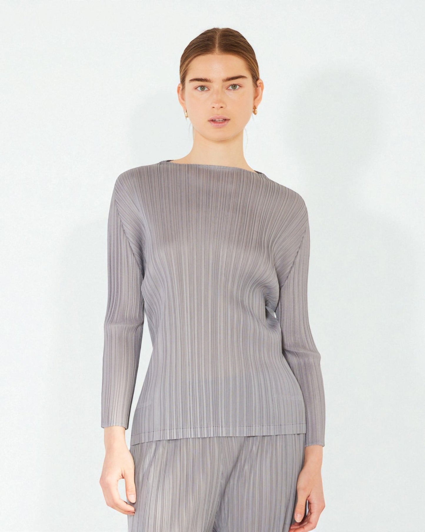 Woman wearing a gray ribbed long-sleeve top on a white background