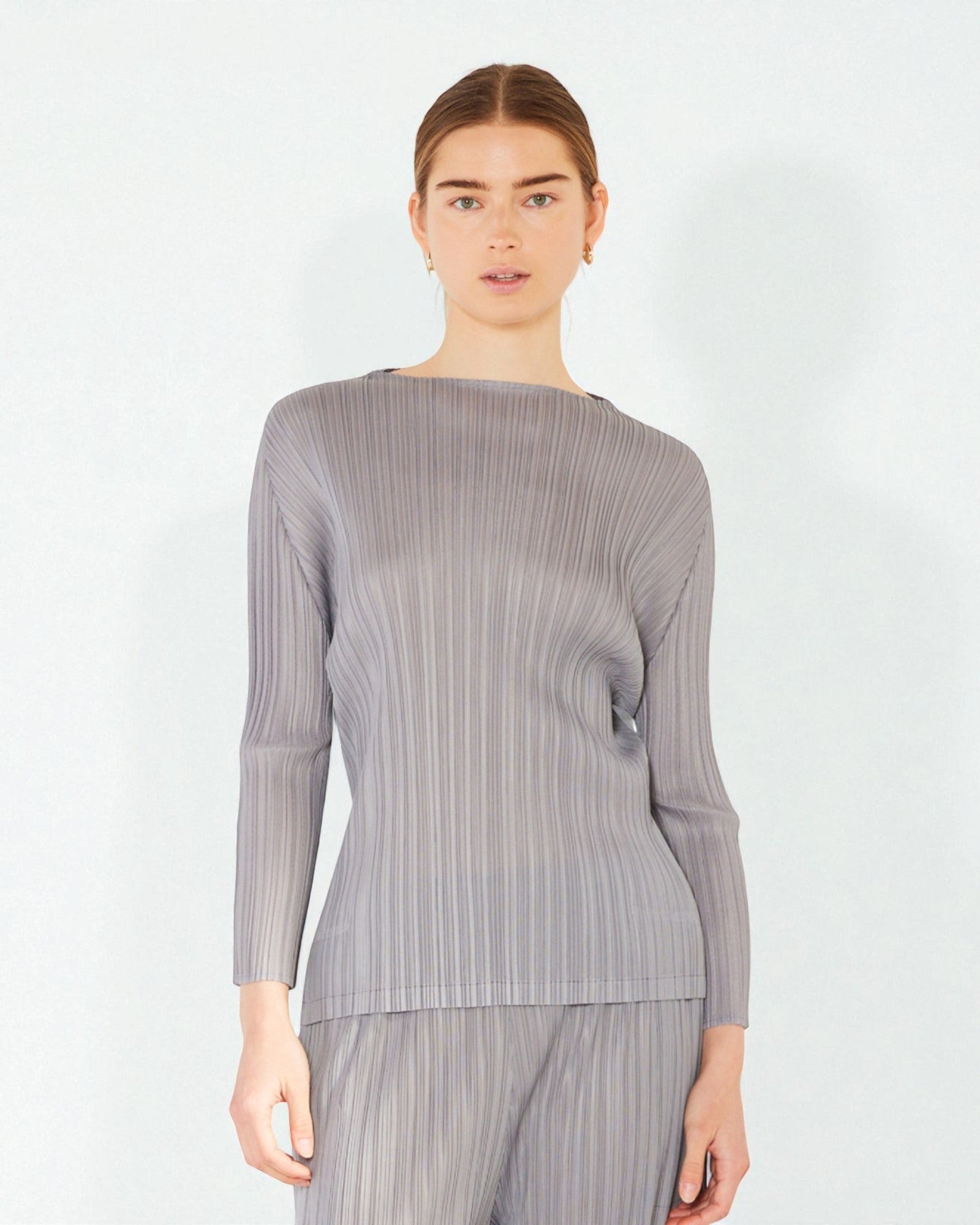 Woman wearing a gray ribbed long-sleeve top on a white background