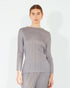 Woman wearing a gray ribbed long-sleeve top on a white background