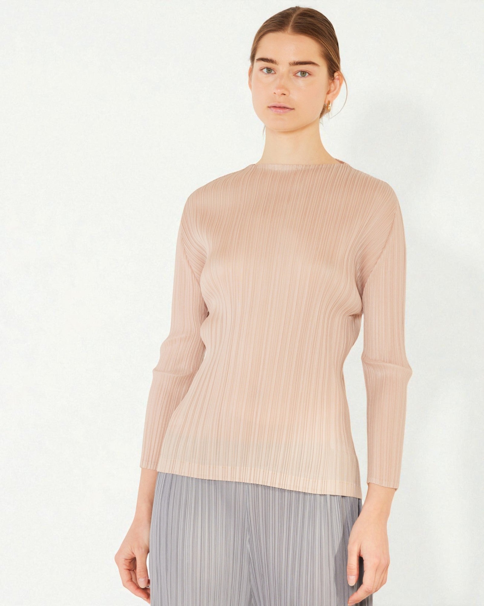 Woman wearing a beige ribbed sweater on a white background