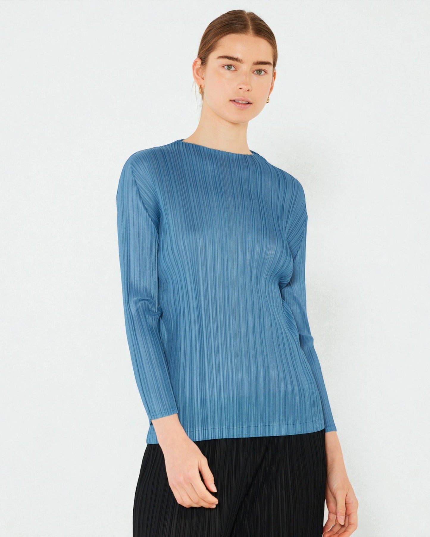 Woman wearing a blue ribbed sweater against a white background