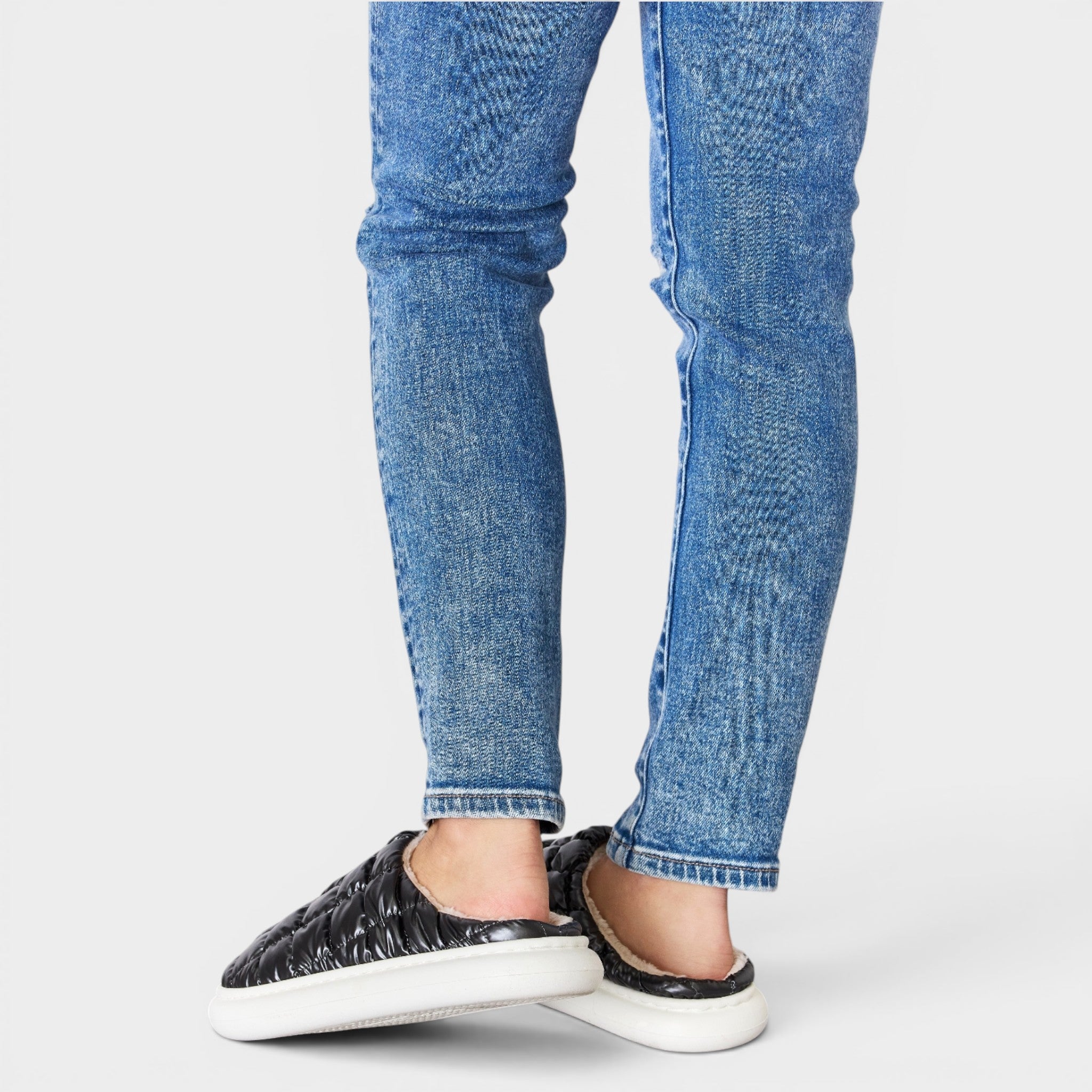 Blue jeans worn by a person on a white background