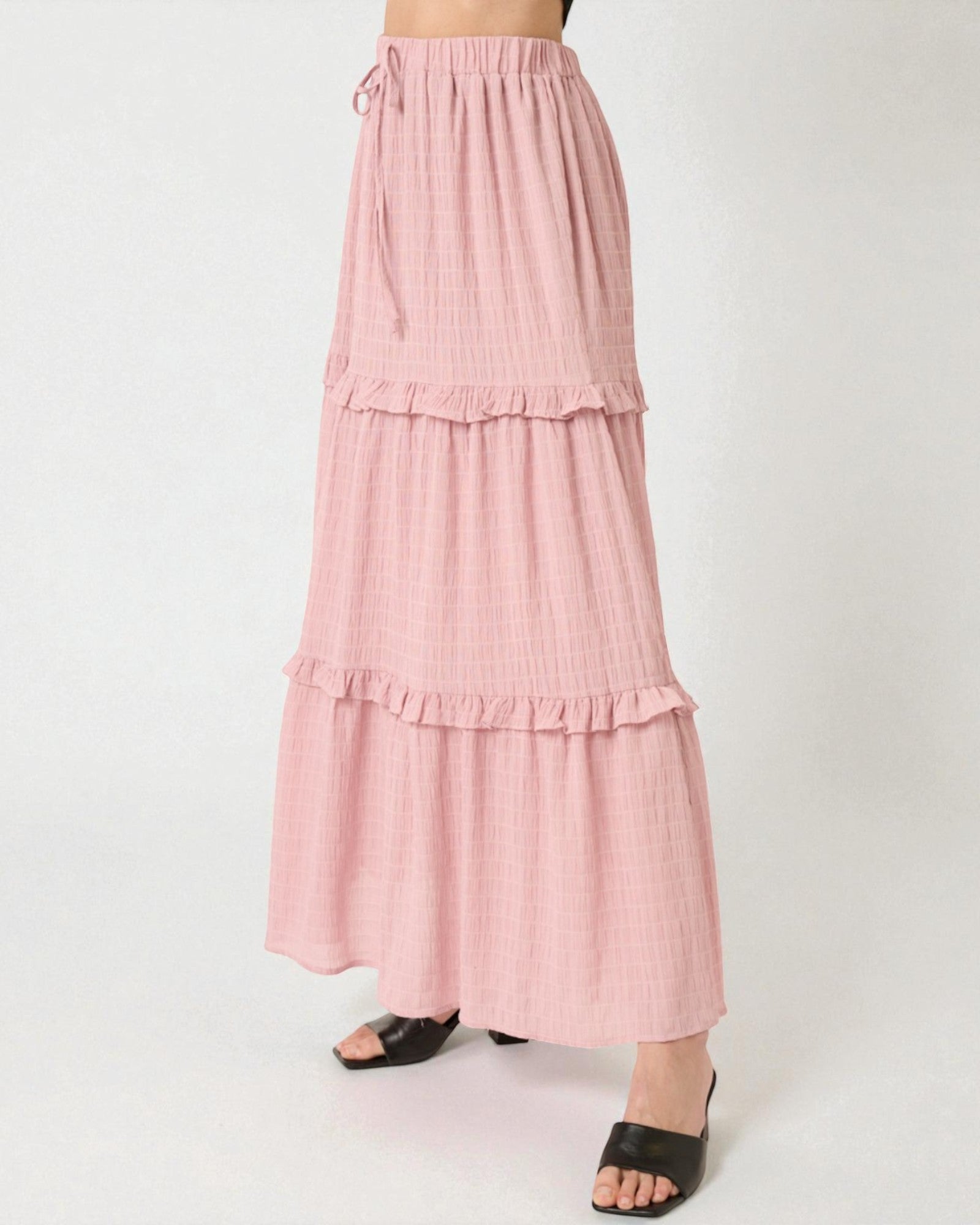 Pink tiered skirt worn by a person on a white background