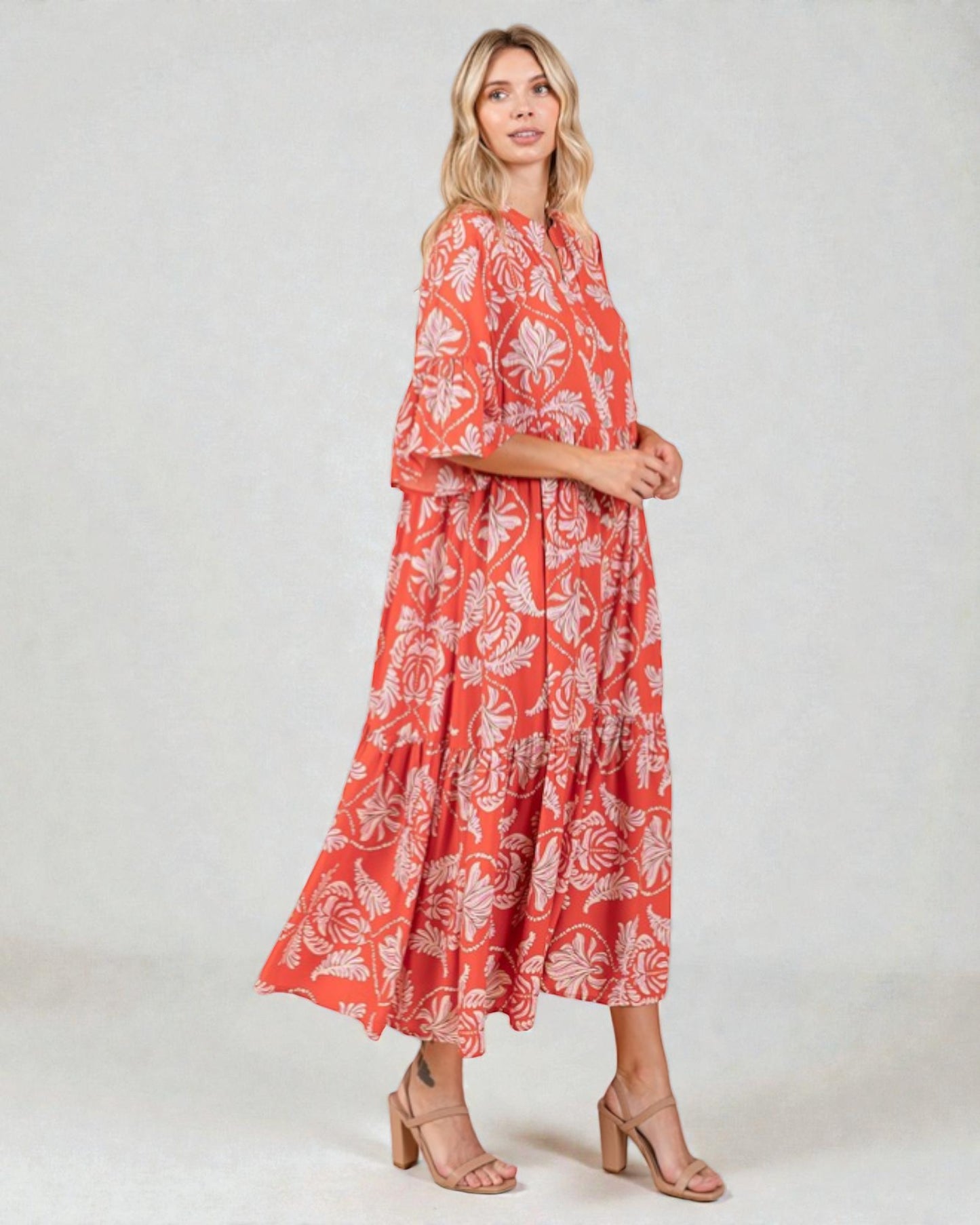 Woman wearing a red floral dress on a white background