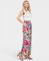 Woman wearing a white top and colorful patterned pants on a white background