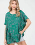 Woman wearing a green patterned top on a white background