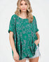 Woman wearing a green floral patterned top on a white background