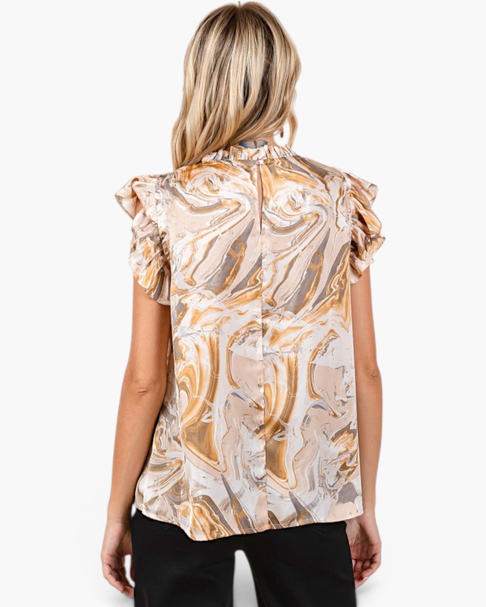 A woman viewed from the back wearing a short-sleeve blouse with a beige, gold, and white marble swirl pattern and ruffled shoulders, paired with black pants, against a plain white background.