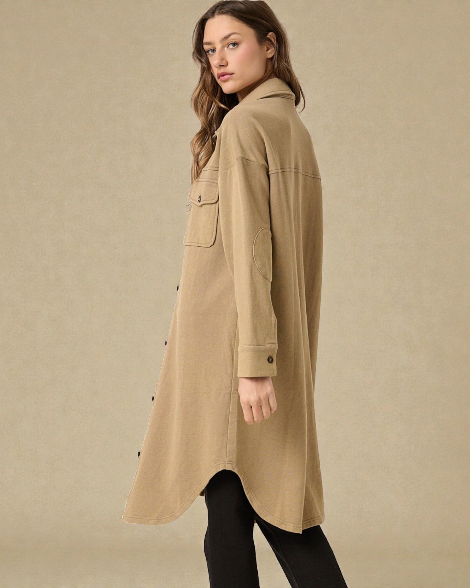 Woman wearing a beige trench coat against a beige background