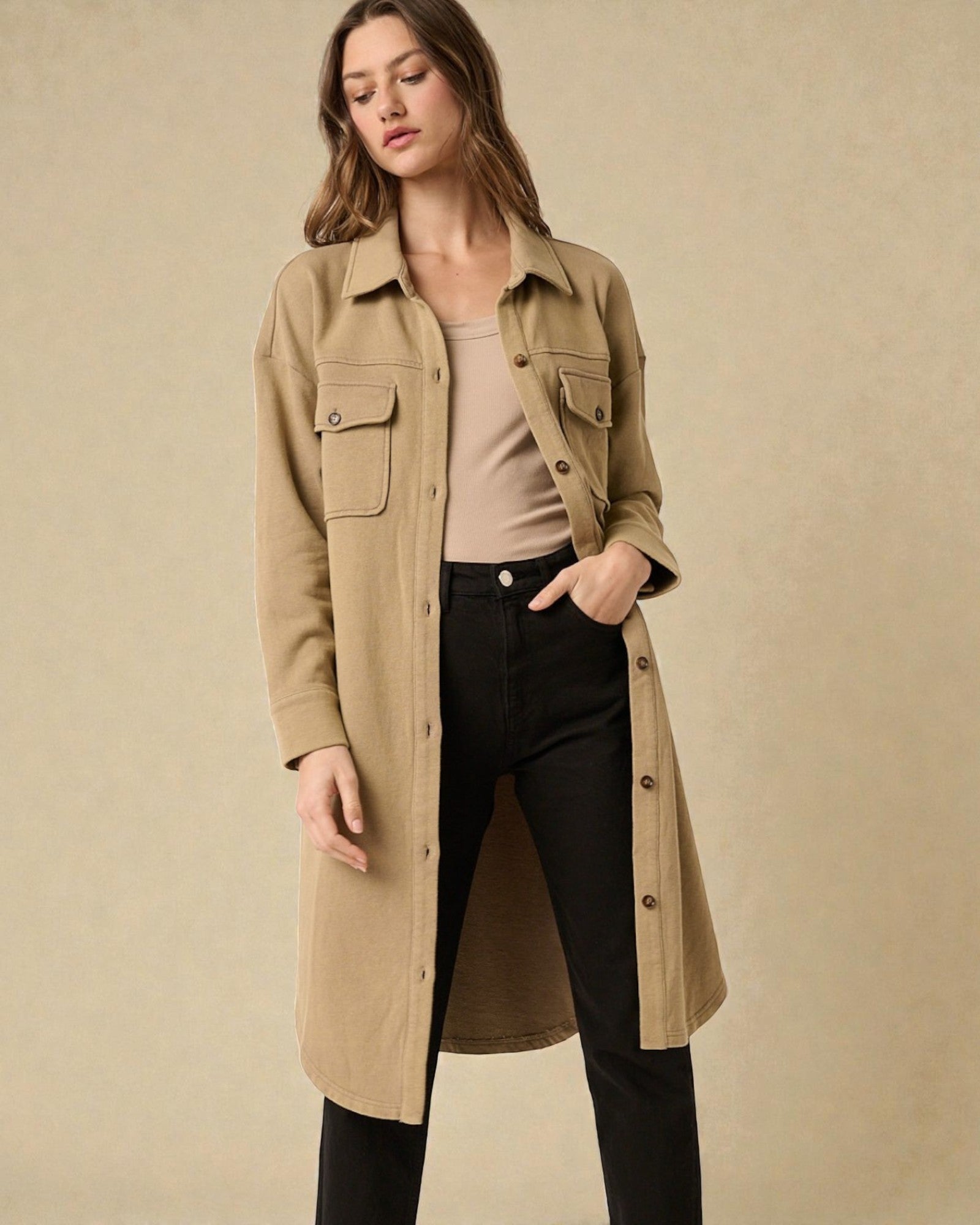 Woman wearing a beige trench coat on a beige background