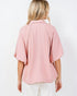 Woman wearing a pink blouse with a white background