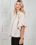Woman wearing a beige blouse with a white background