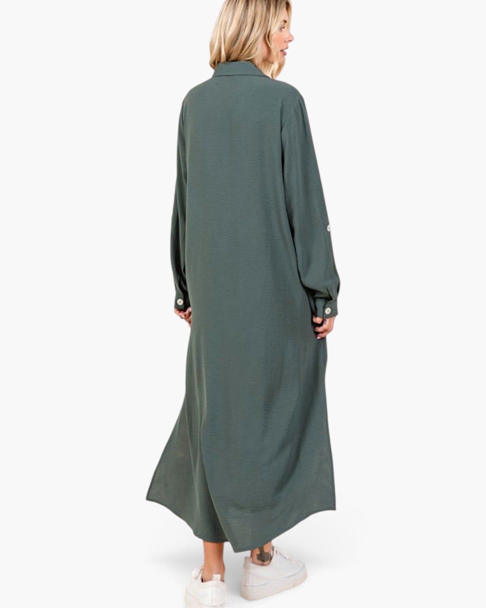 A woman wearing a long-sleeved, button-front maxi shirt dress in a muted sage green, shown from the back against a plain white studio background.
