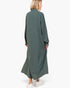 A woman wearing a long-sleeved, button-front maxi shirt dress in a muted sage green, shown from the back against a plain white studio background.