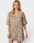 Woman wearing a leopard print dress on a plain background