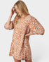 Woman wearing a leopard print dress on a white background