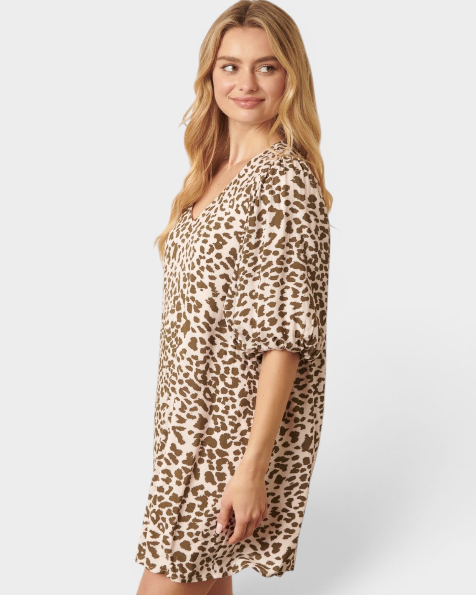 Woman wearing a leopard print dress on a white background