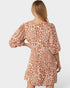 Woman wearing a leopard print dress on a white background