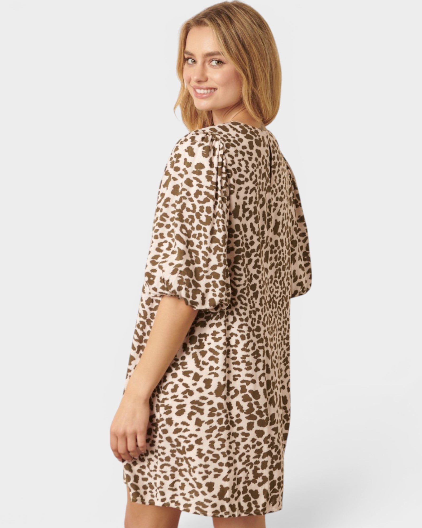 Woman wearing a leopard print dress on a white background