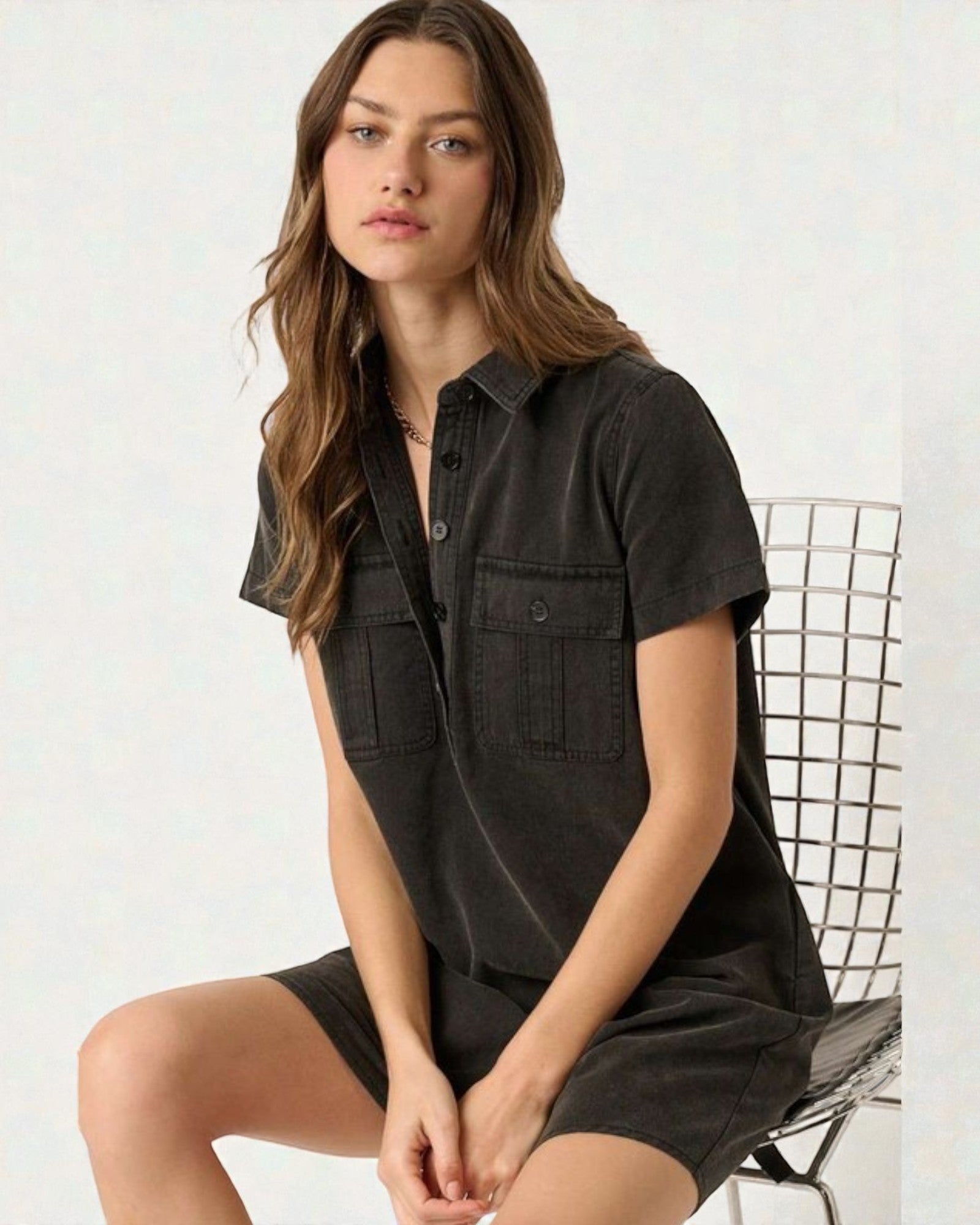 Woman wearing a black short-sleeve shirt and shorts on a white background