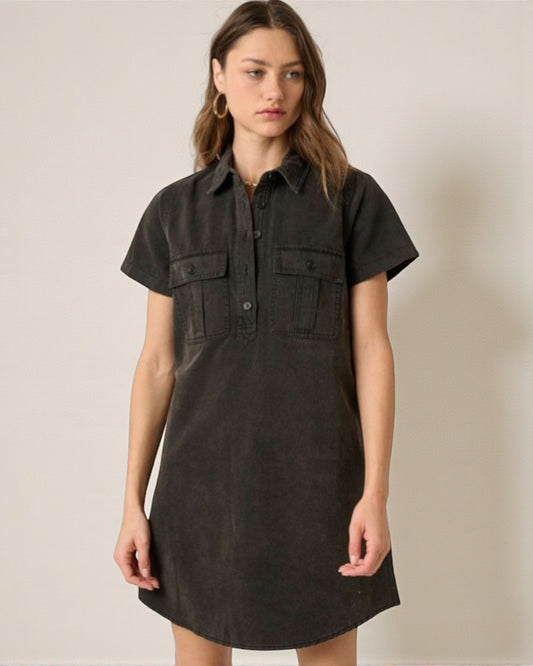 Woman wearing a black short-sleeve dress against a beige background