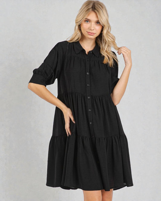 Woman wearing a black dress against a gray background