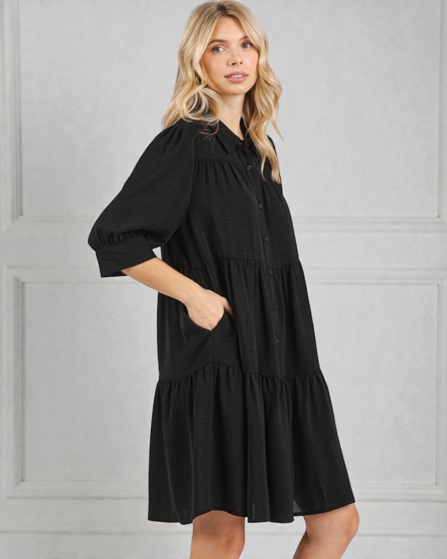 Woman wearing a black dress against a gray background