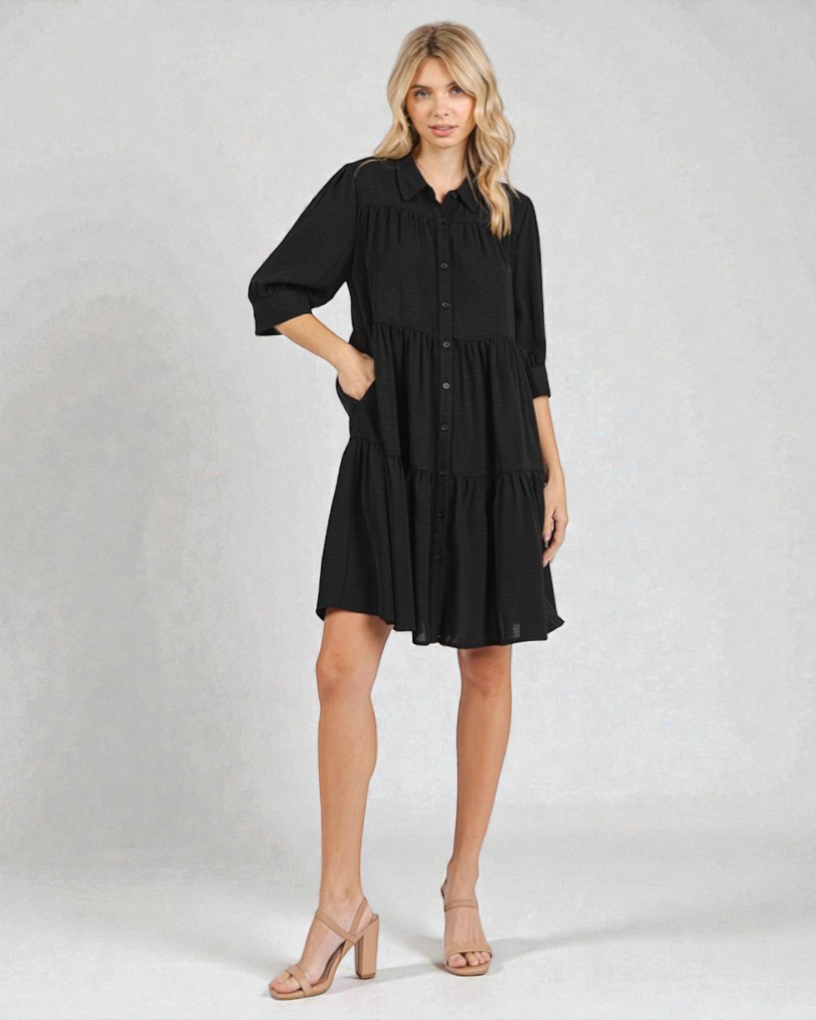 Woman wearing a black dress on a plain background