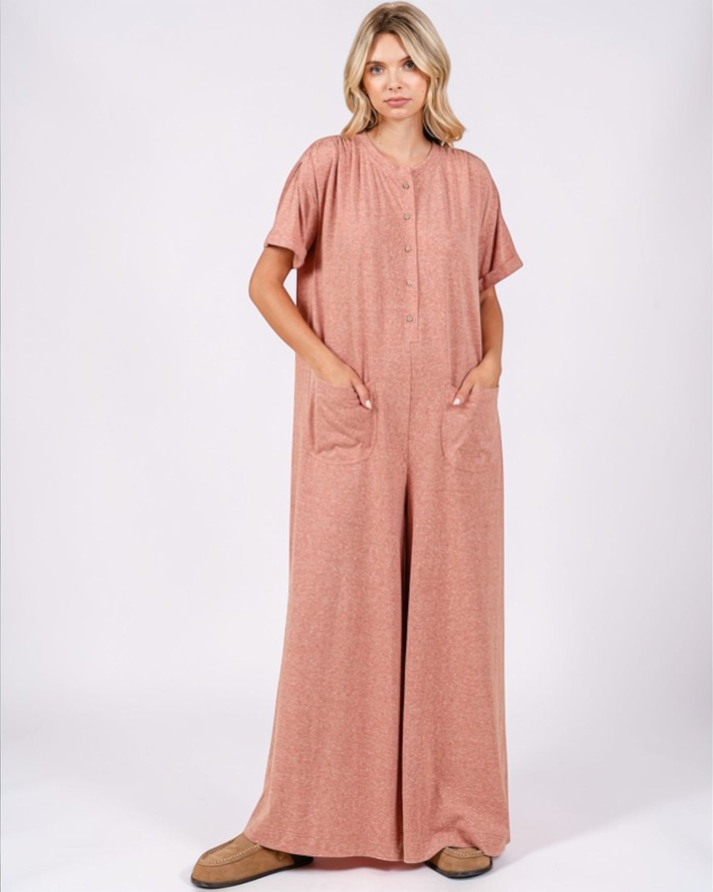 Woman wearing a pink jumpsuit on a white background