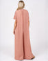 Woman wearing a pink jumpsuit on a white background