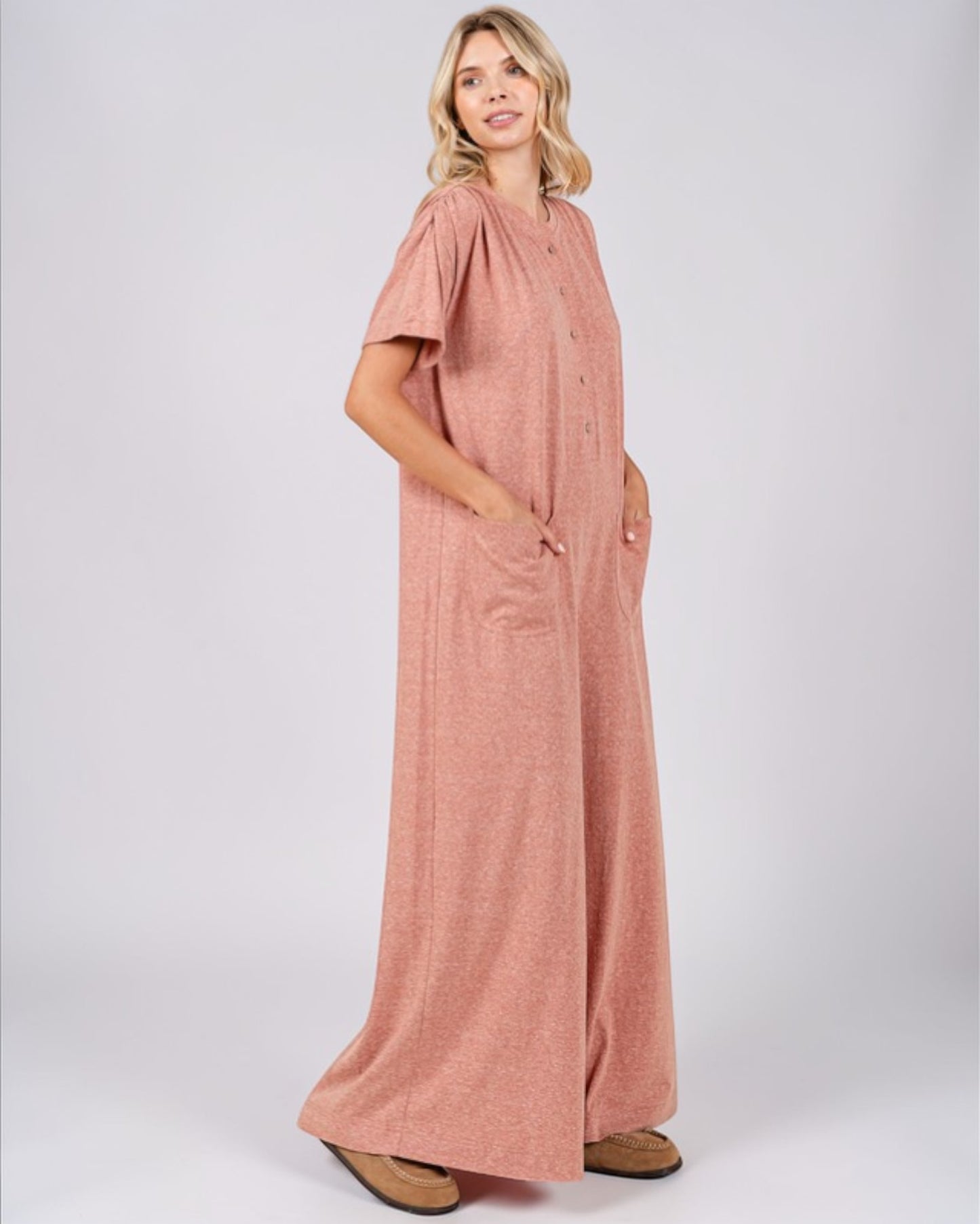 Woman wearing a pink jumpsuit on a white background