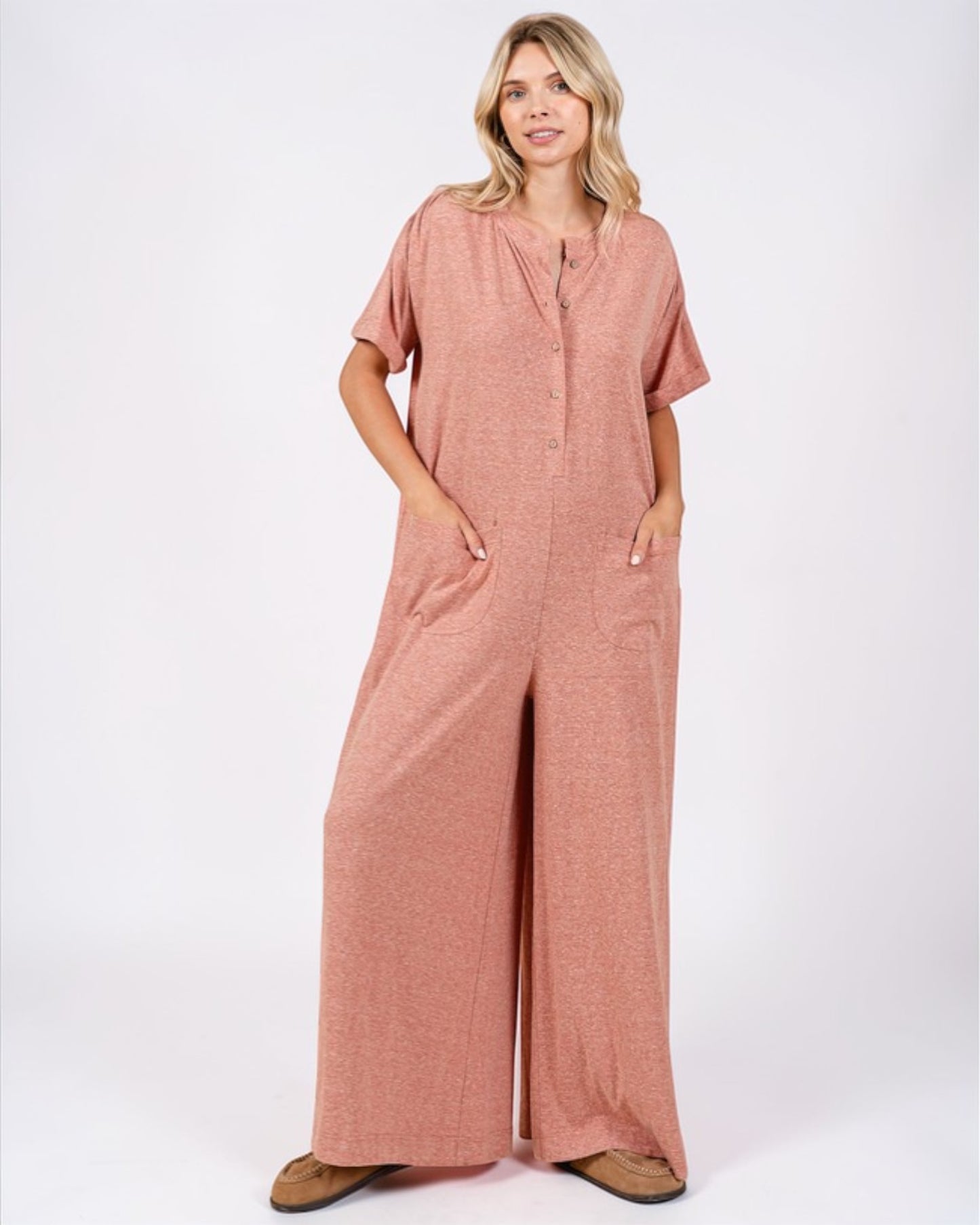 Woman wearing a pink jumpsuit on a white background