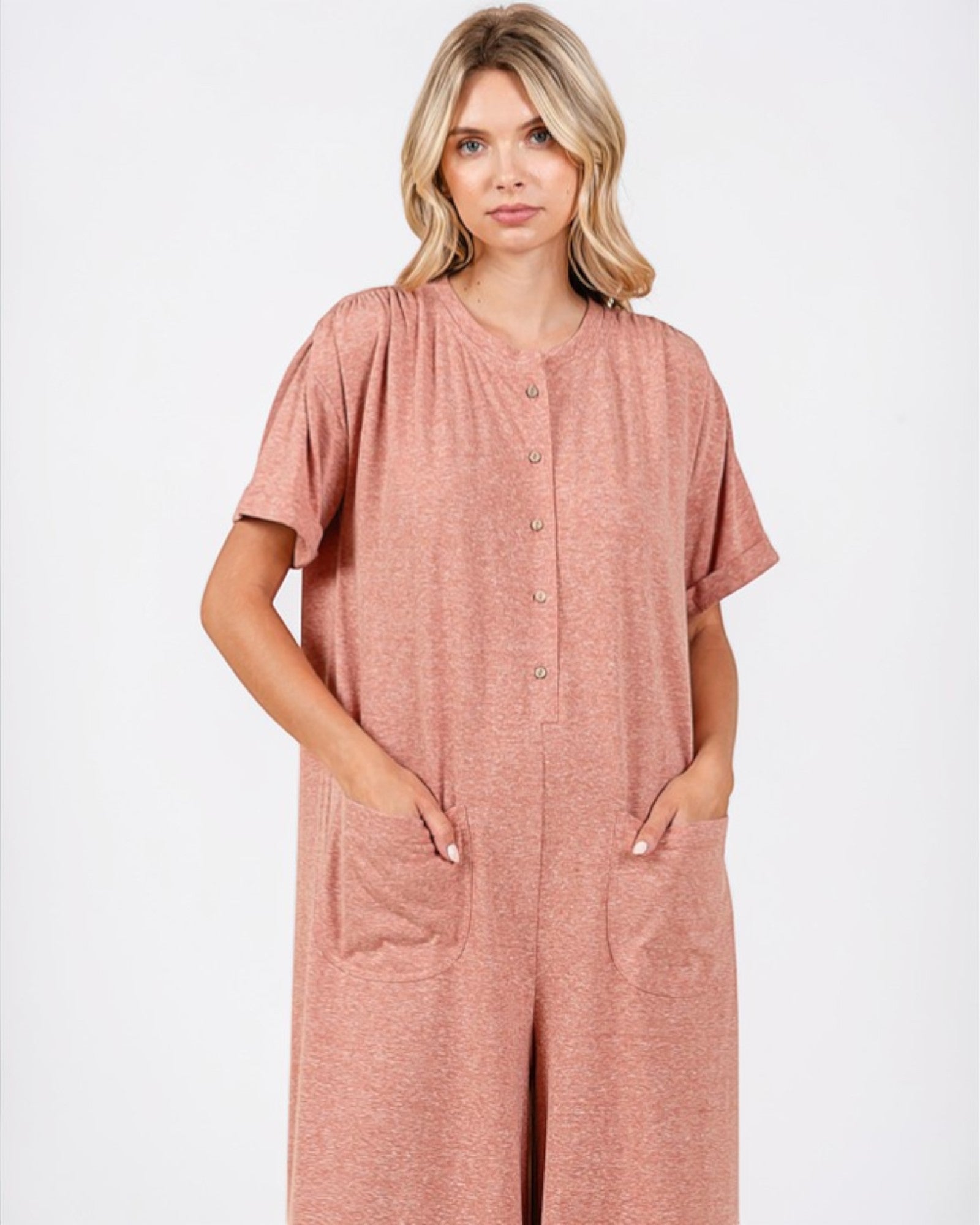 Woman wearing a pink jumpsuit on a white background