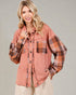 Woman wearing a plaid shirt with a pinkish-brown color scheme on a gray background