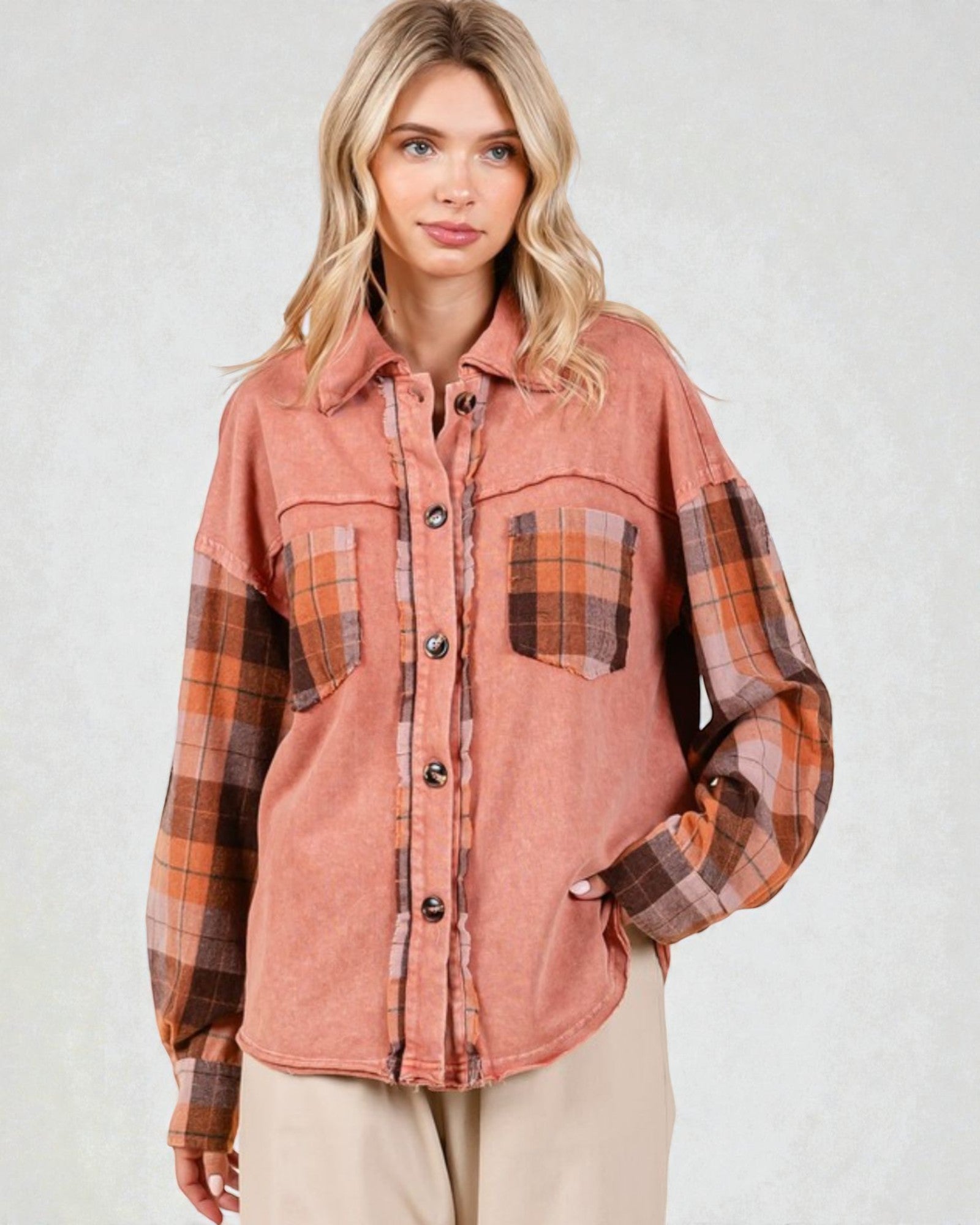 Woman wearing a plaid shirt with a pinkish-brown color scheme on a white background