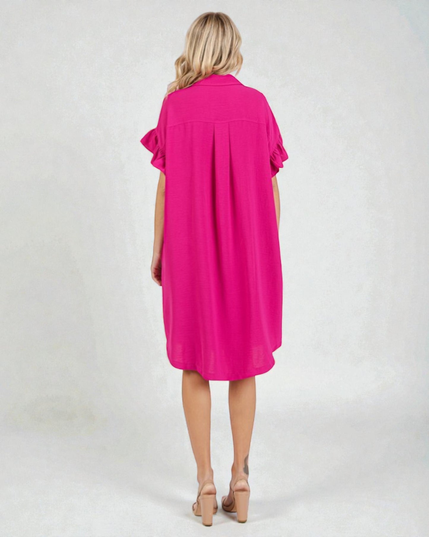 Woman wearing a bright pink dress on a white background